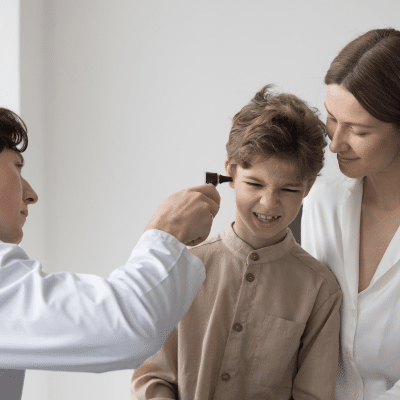 ENT specialist checking a little boy's ear while mother sits beside him, representing ear infections in kids
