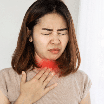 Woman holding her throat, representing sore throat that wont go away